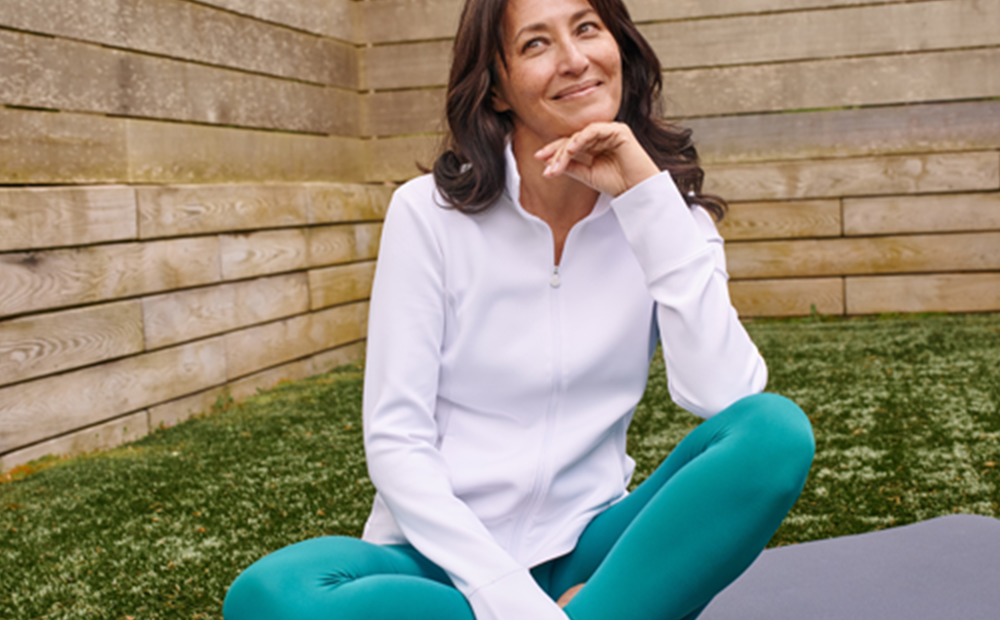 happy active woman sitting on the ground with less knee pain