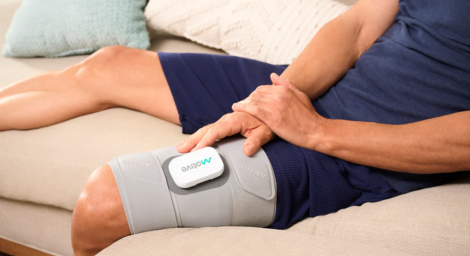 man with knee pain completing a motive therapy session at home
